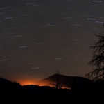 Lueur d'un feu et filés d'étoiles à Sunset Crater