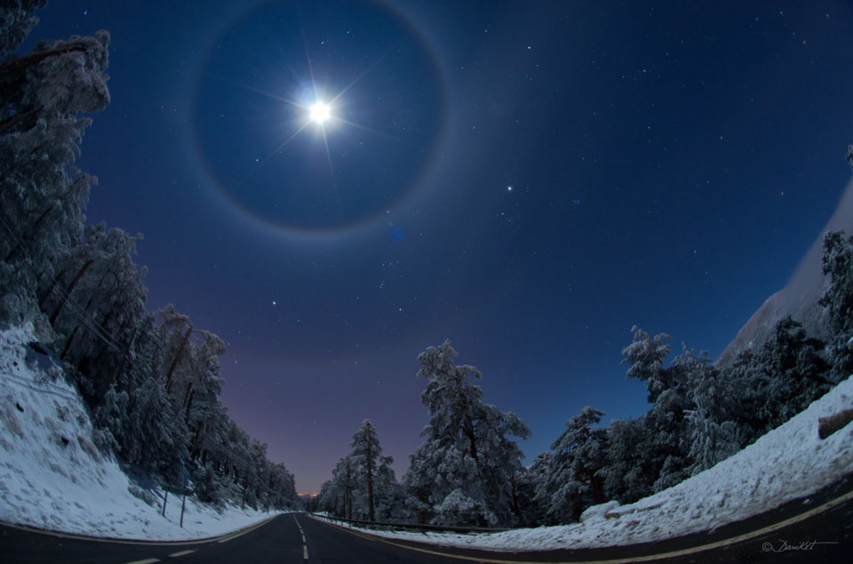 Quadruple halo lunaire sur une route d\'hiver